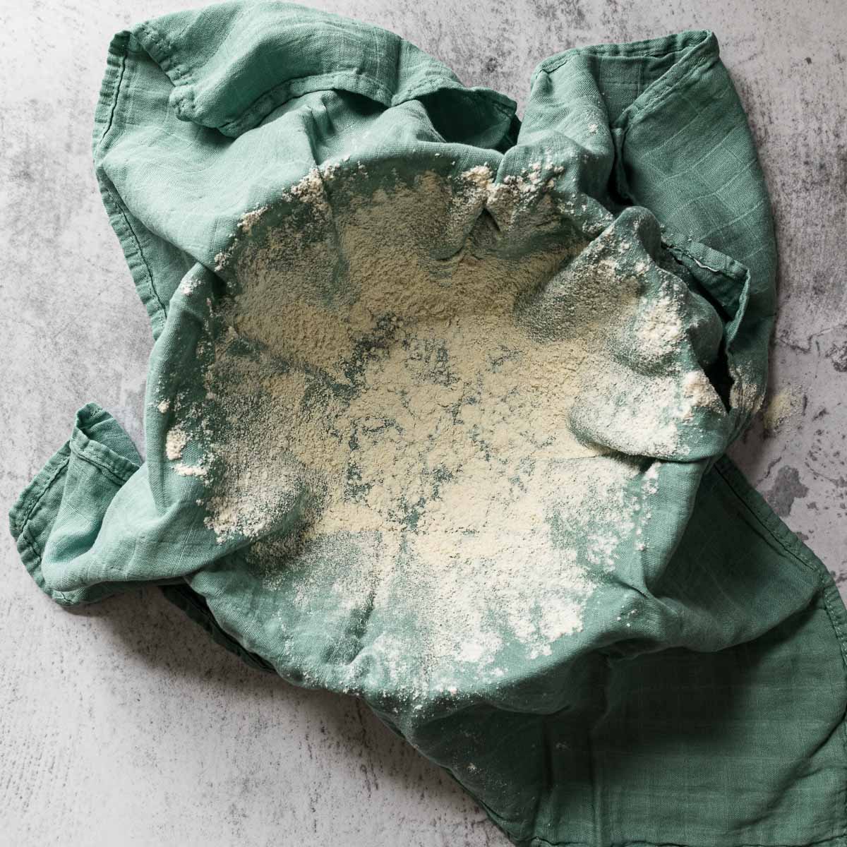 Mixing bowl lined with a tea towel and dusted with flour.