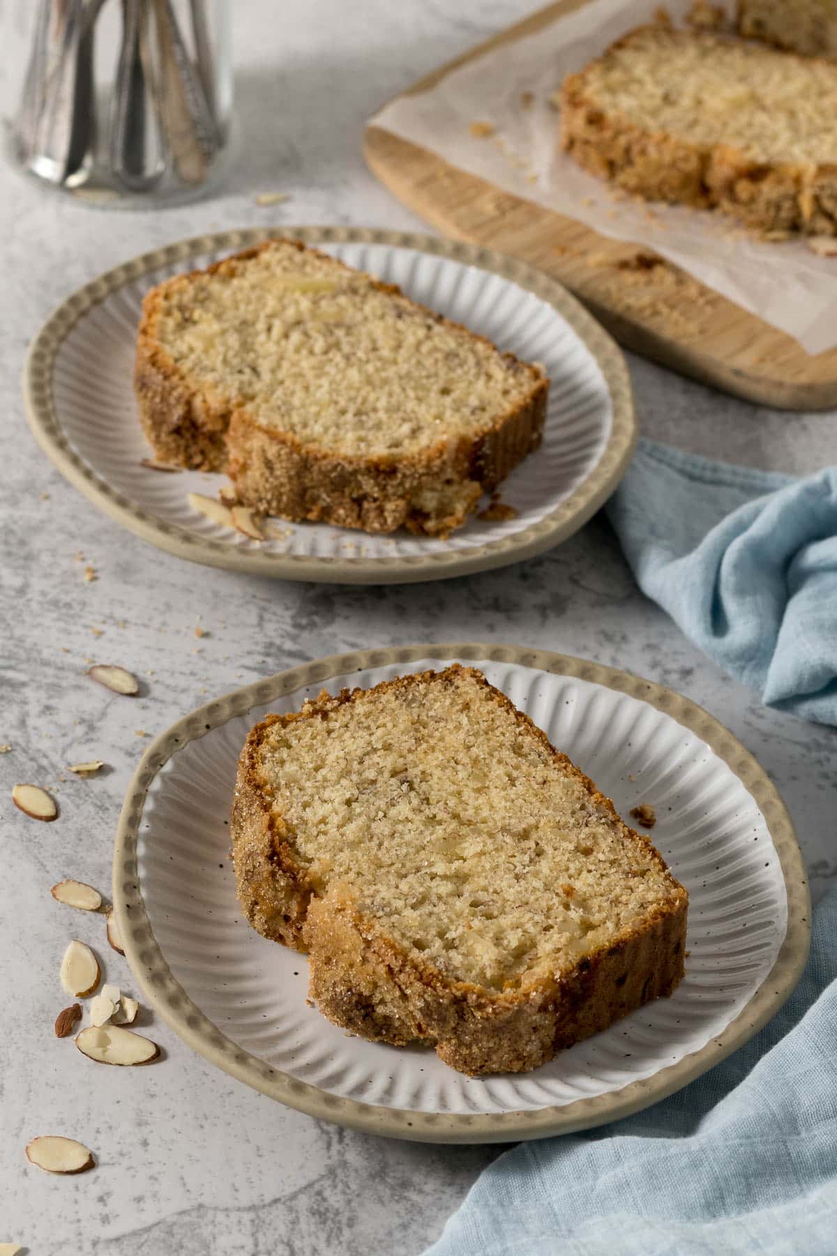 Slices of banana bread with almonds on plates.