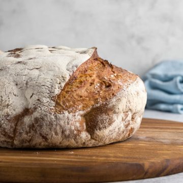 Close up side view of entire country bread loaf.