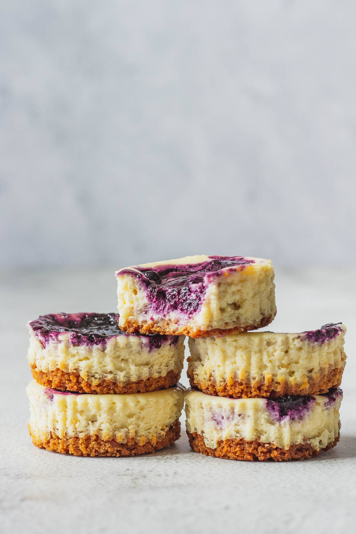 Stack of mini blueberry cheesecakes.