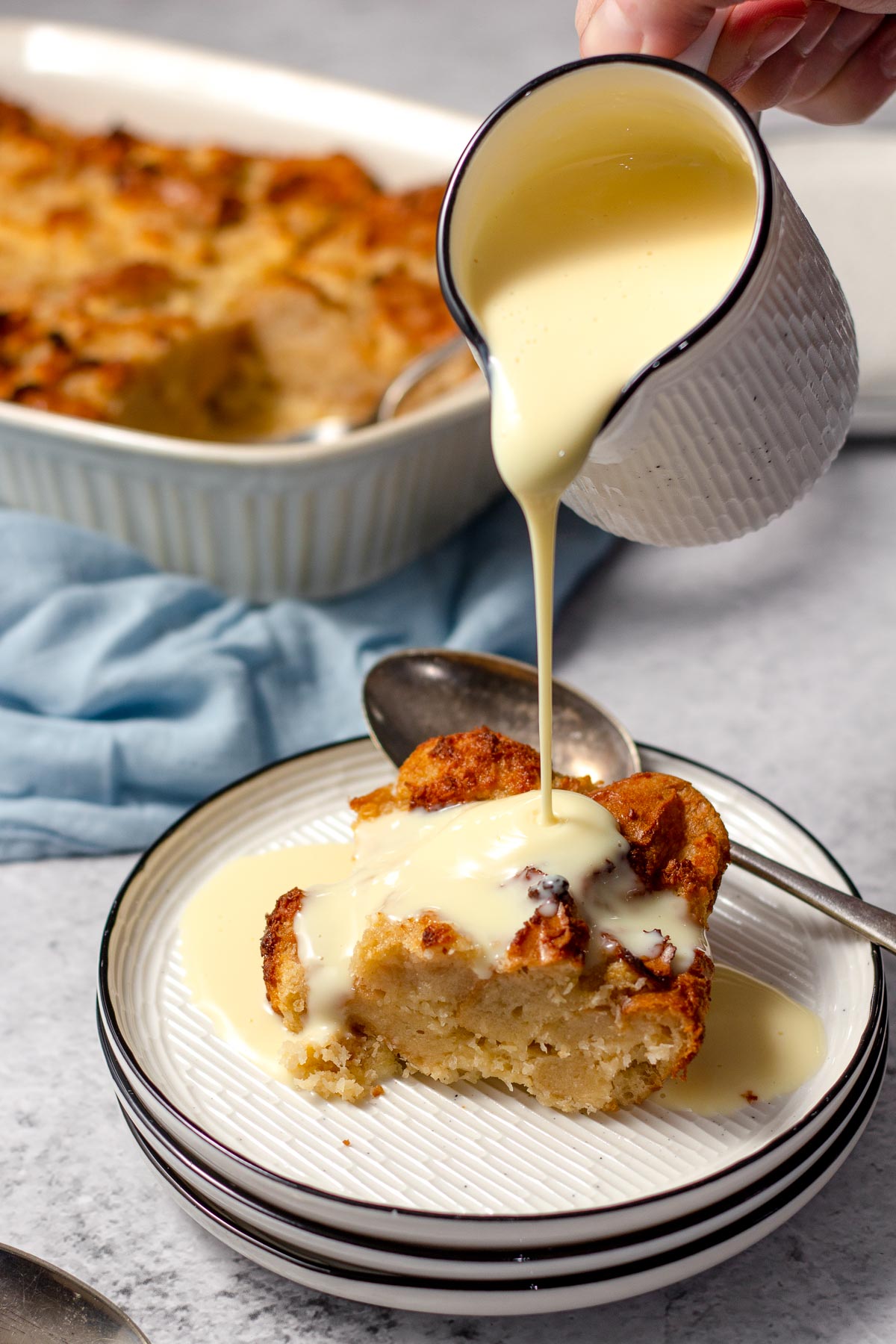 Custard being poured over coconut bread pudding 