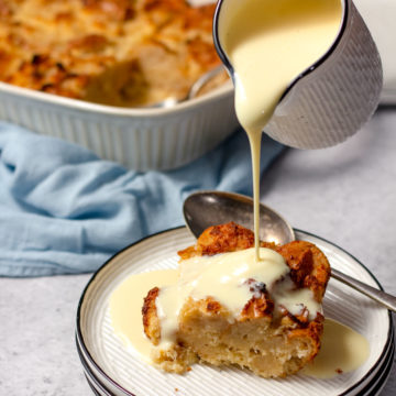 Custard being poured over coconut bread pudding.