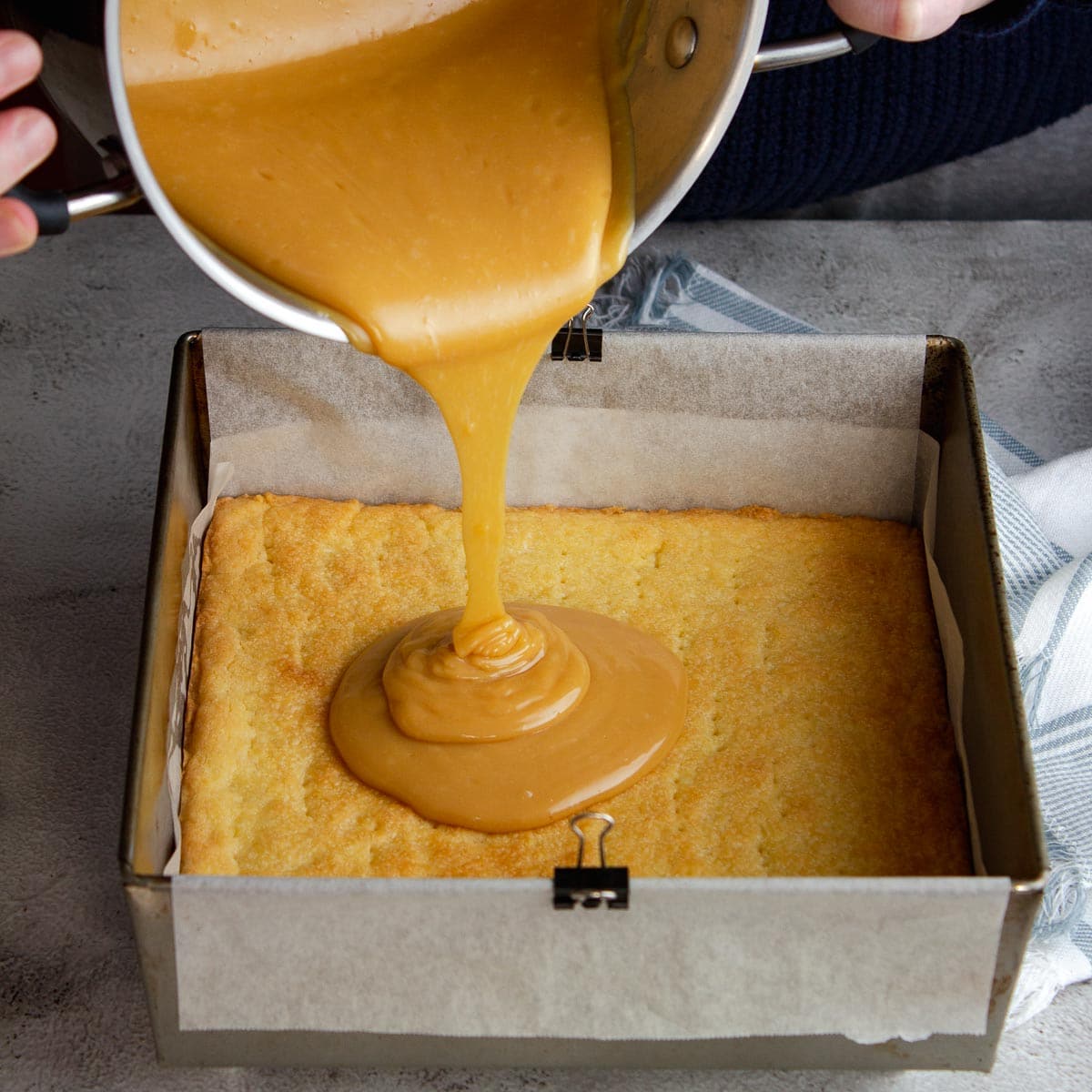 Pouring caramel onto the biscuit base