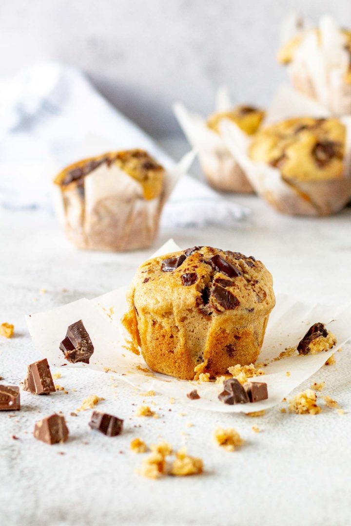 Chocolate chip muffin surrounded by chunks of chocolate.