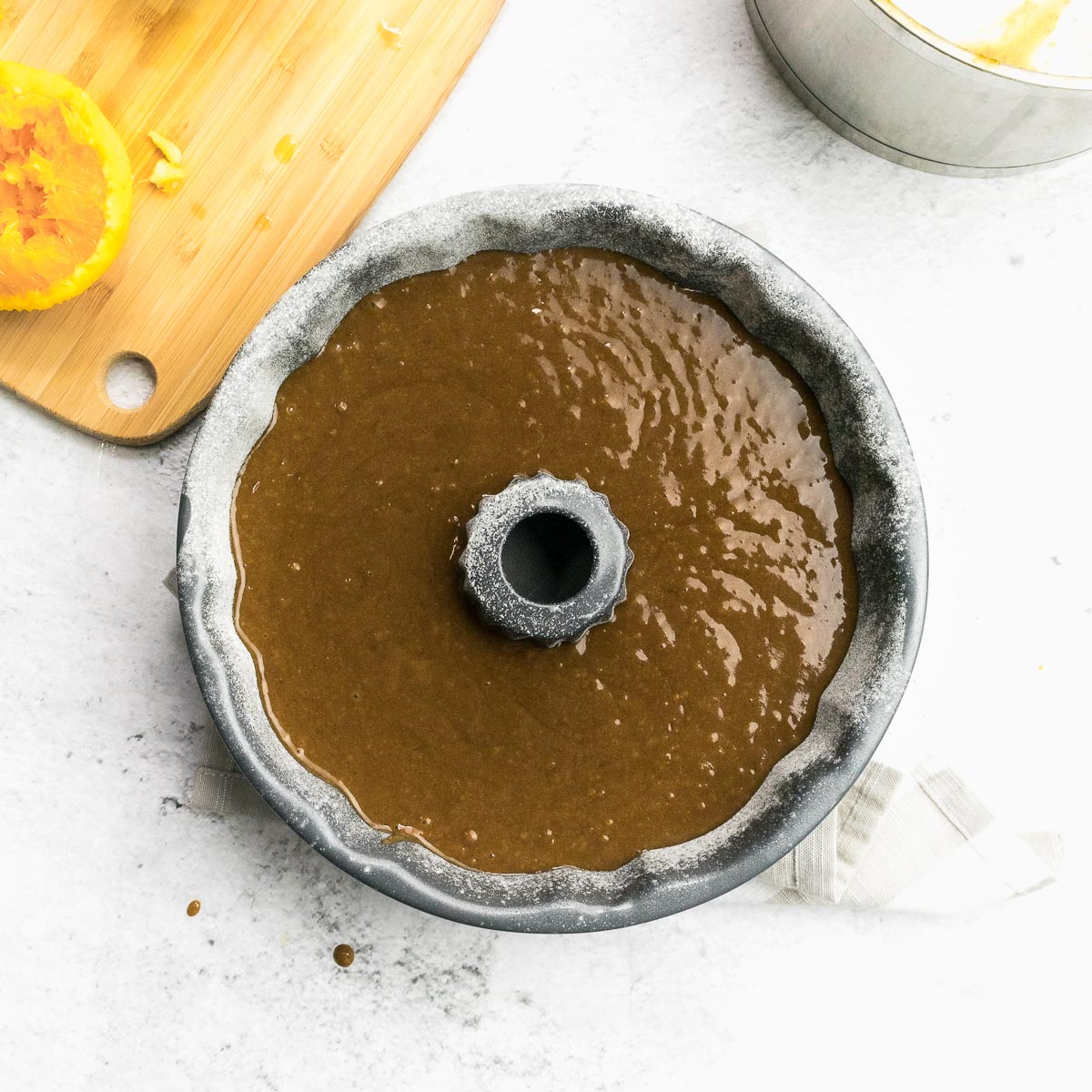 orange gingerbread cake batter poured into bundt pan