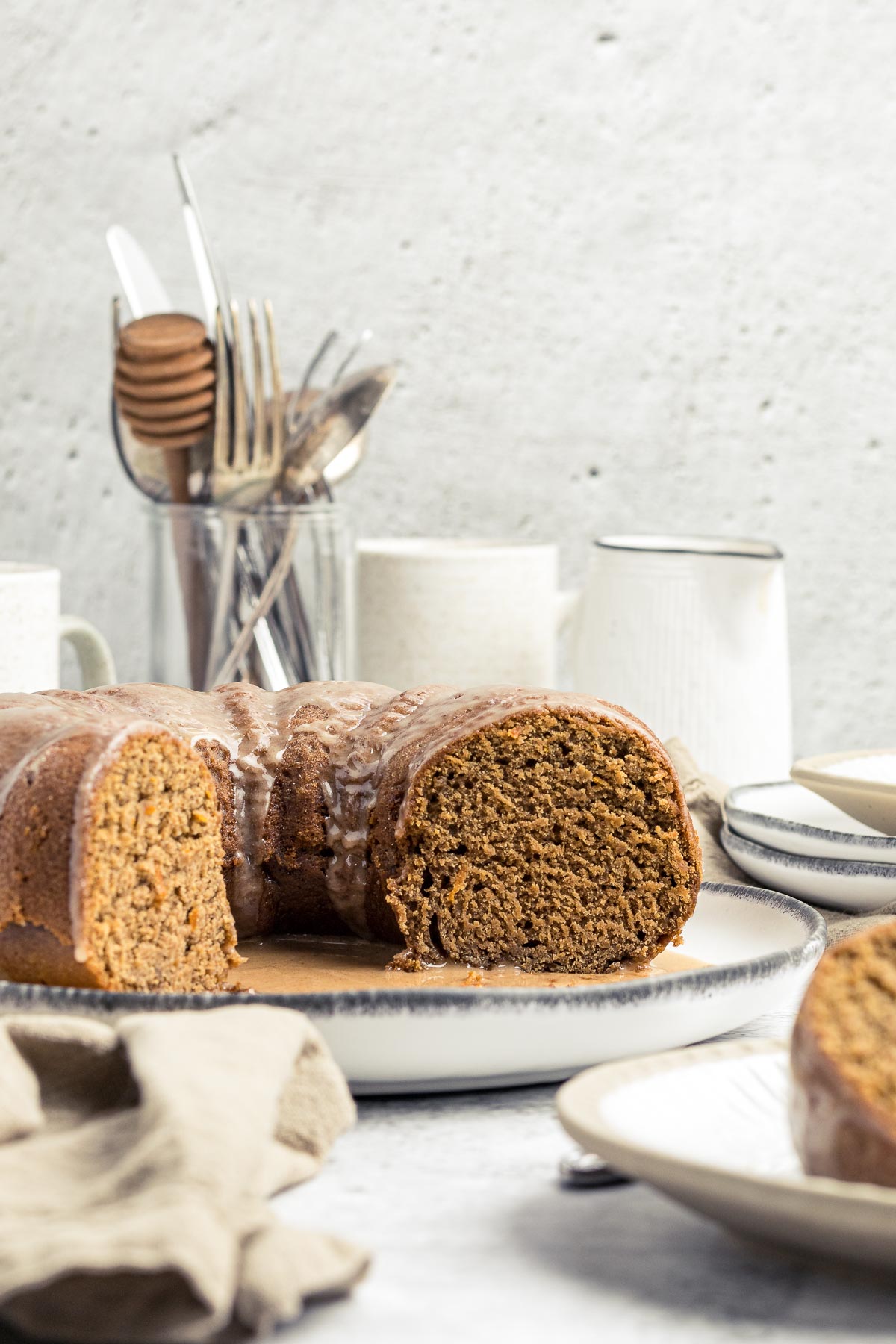 Sliced orange gingerbread bundt cake with glaze showing the crumb of the cake
