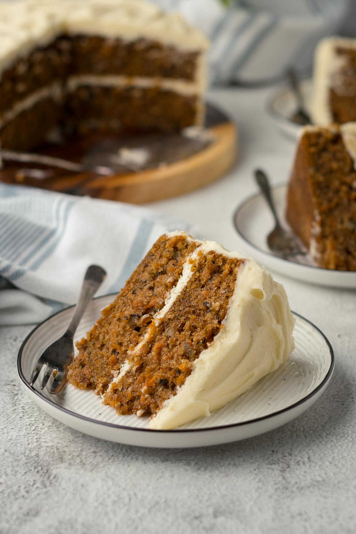 Slice of carrot cake showing cream cheese icing (frosting).