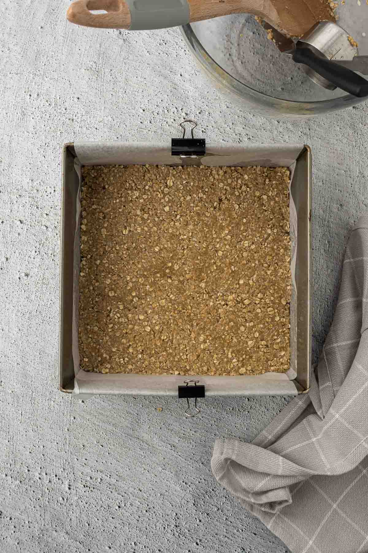 Crunchie batter pressed into tin.