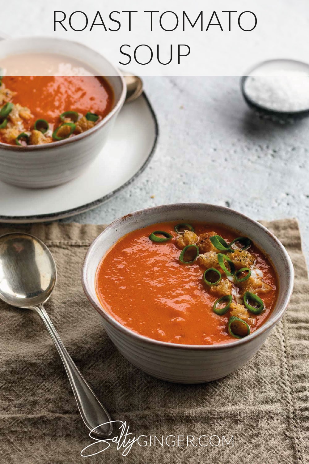 Bowl of tomato soup with a brown napkin.