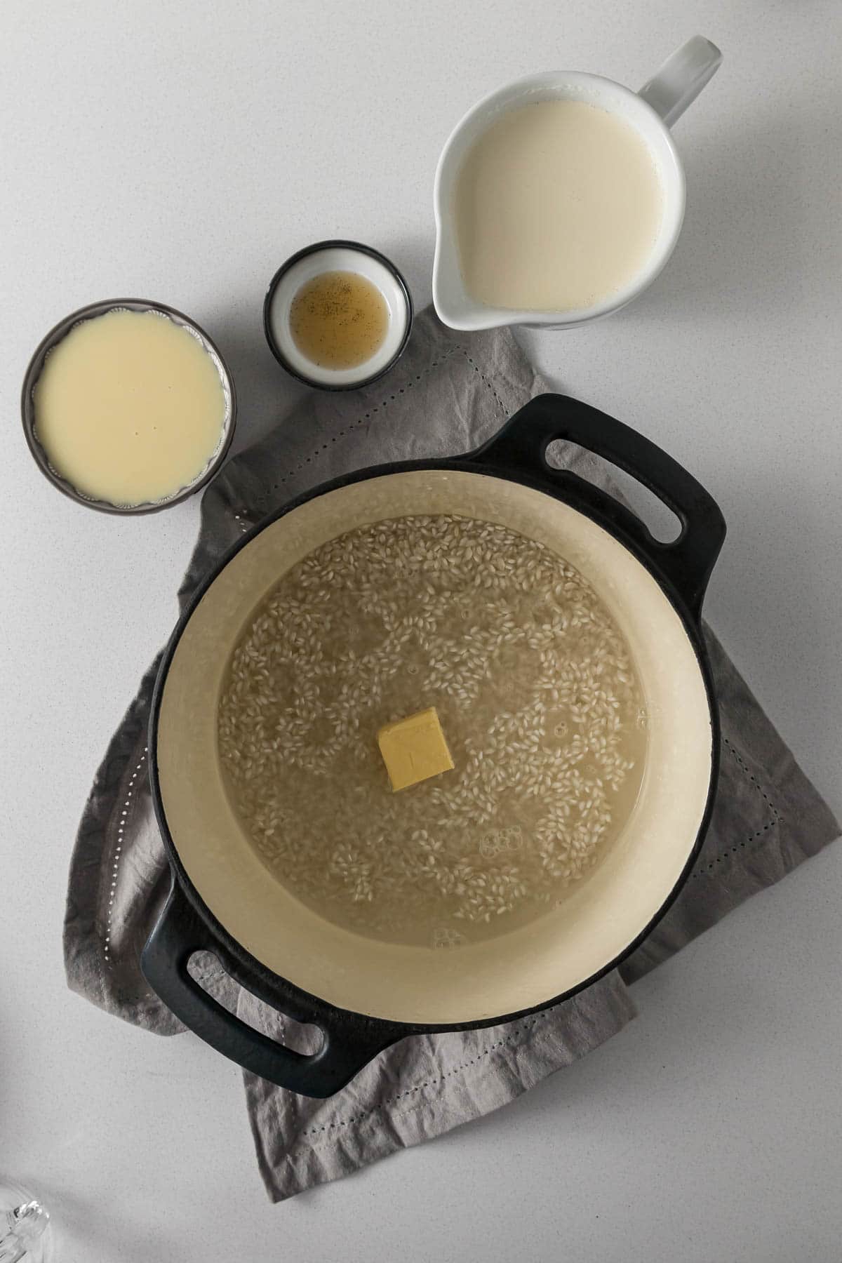 Water, rice, butter and salt combined in a pot.