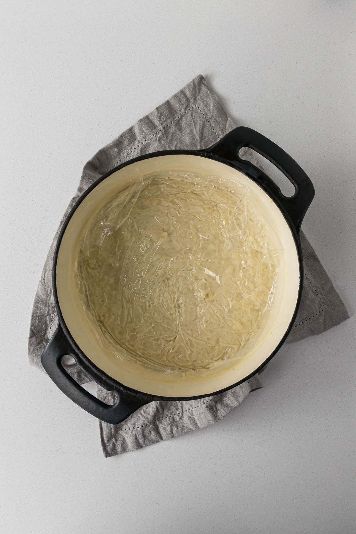 Rice pudding covered with cling film while it cools.