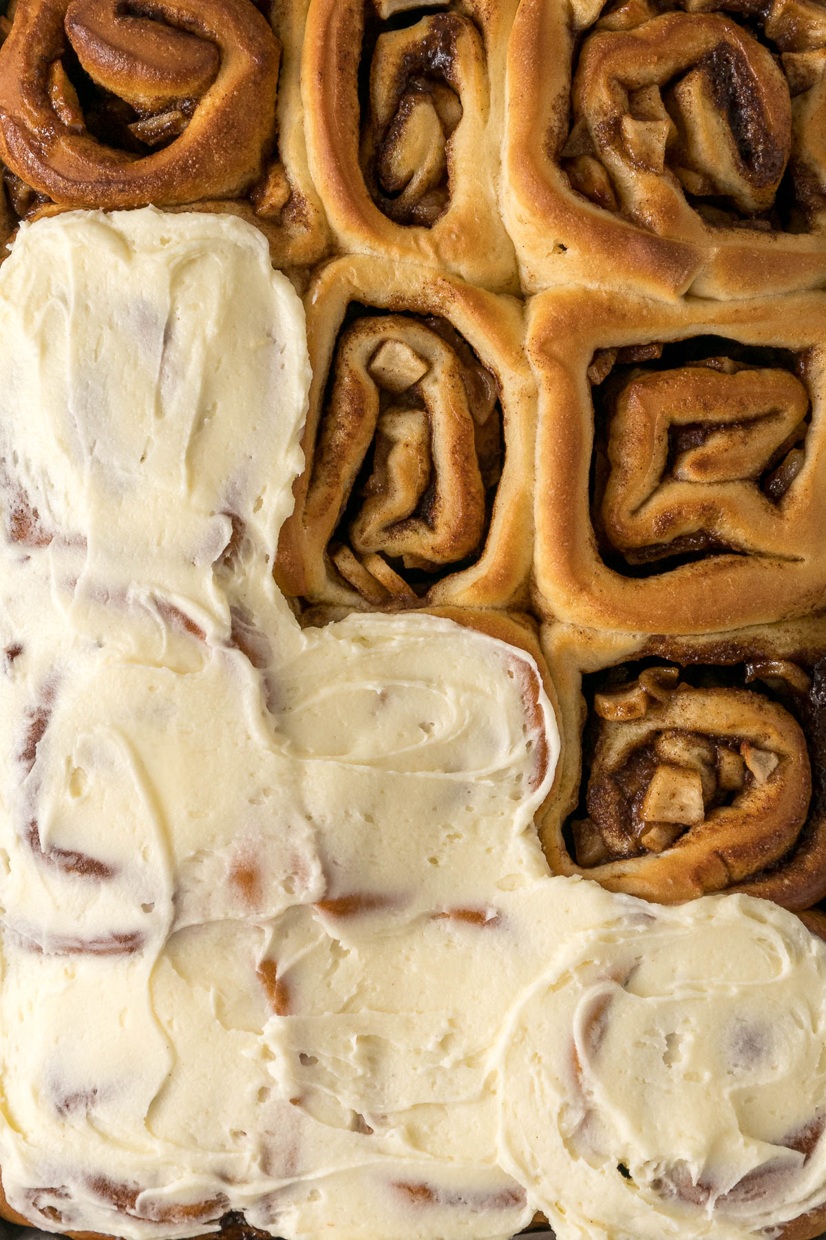 A tray of cinnamon rolls with apple pie filling.