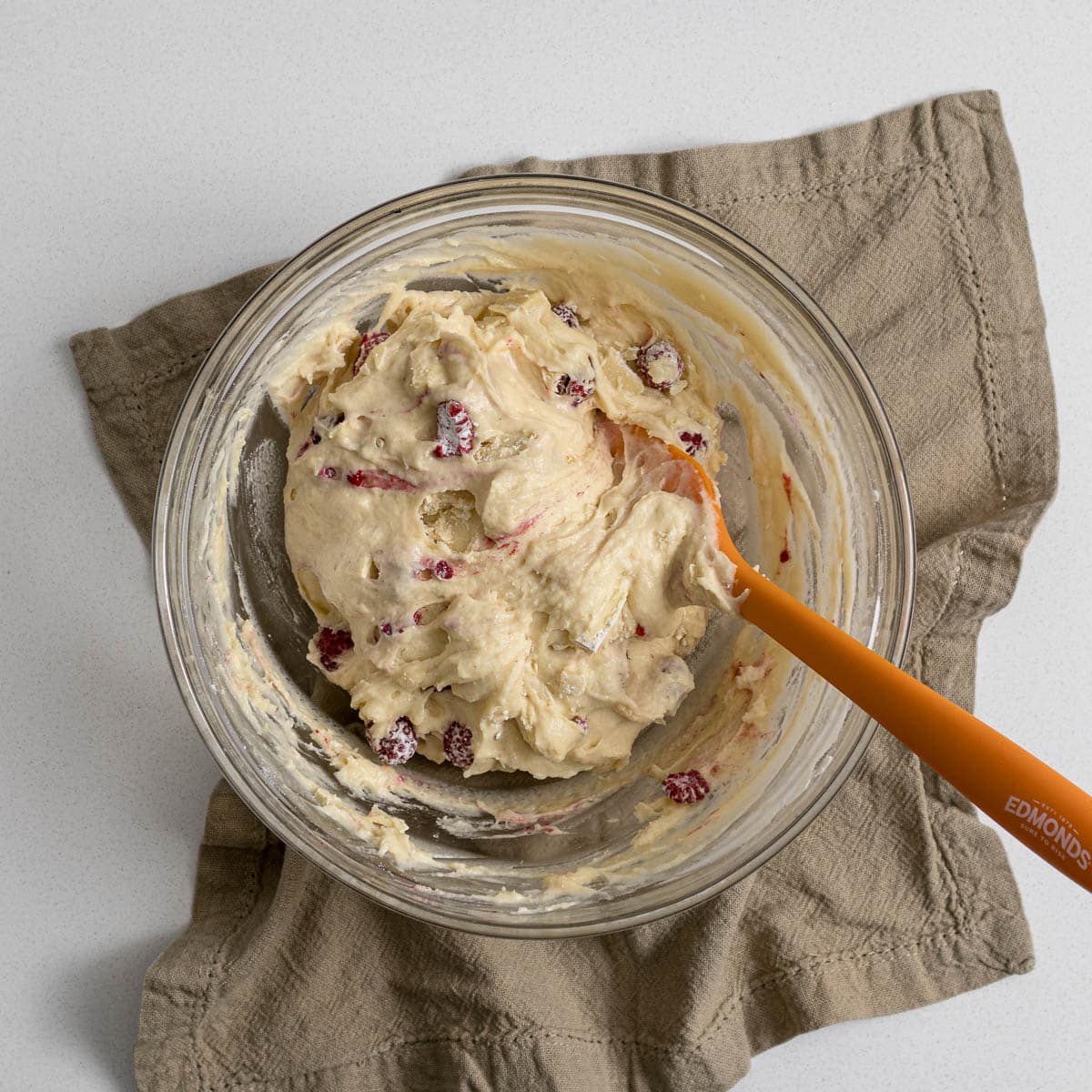 Raspberry and white chocolate cake batter in a bowl.