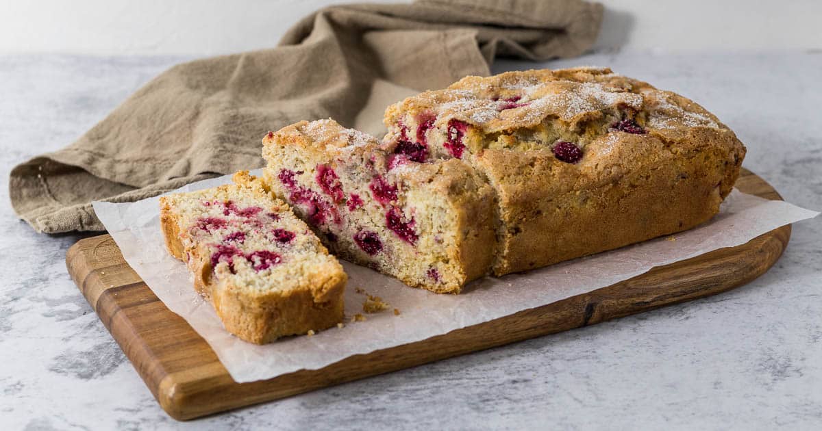Slice of raspberry and white chocolate loaf cake.
