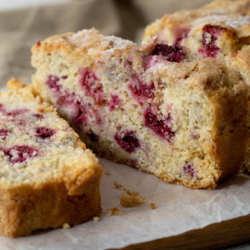 Slice of raspberry and white chocolate loaf cake.