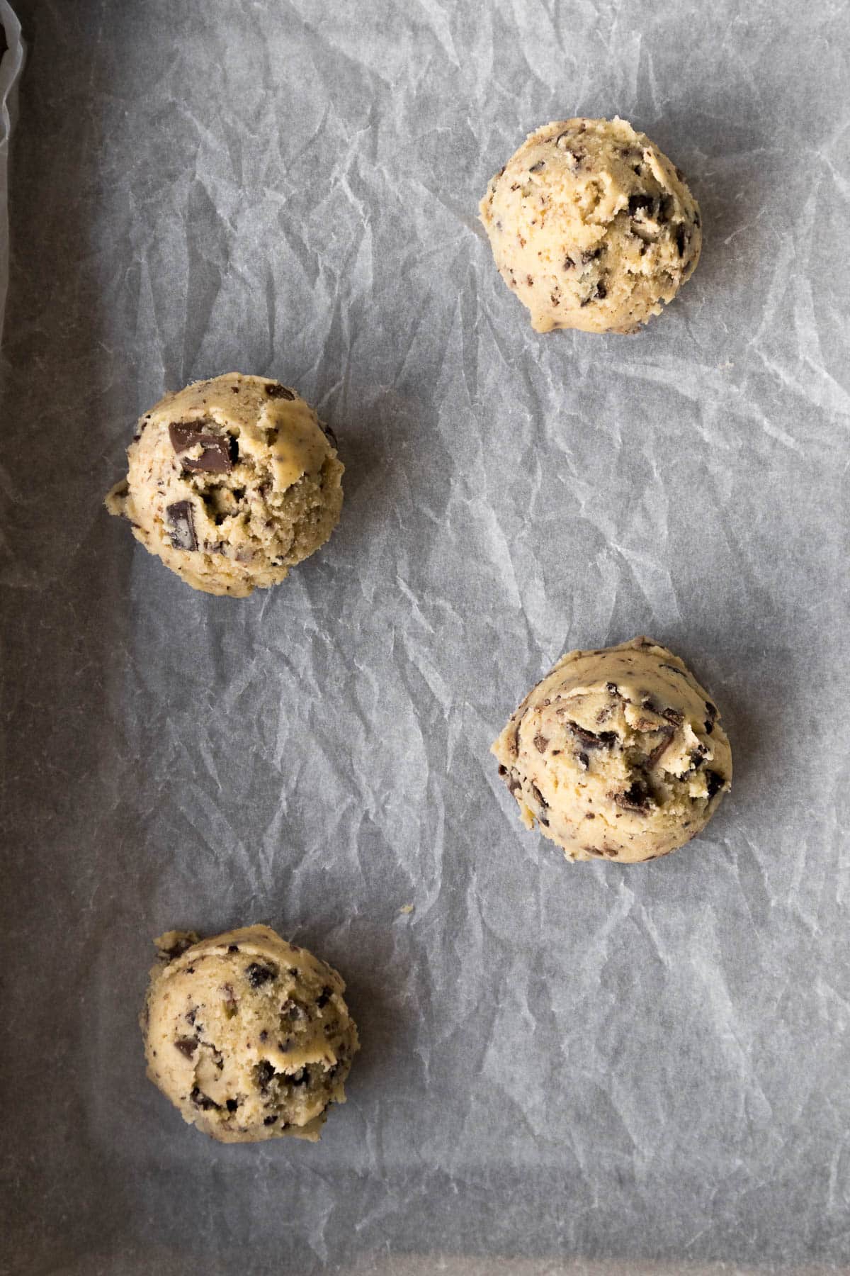 Scoops of cookie dough on a baking sheet.