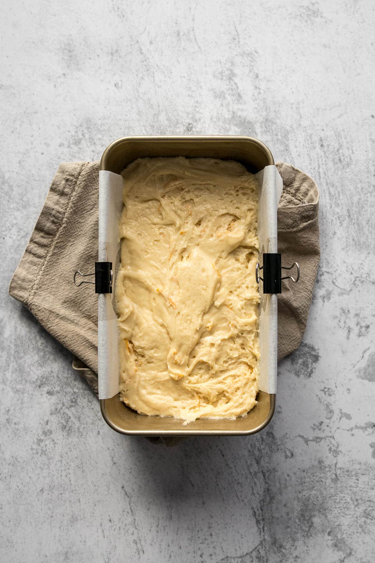 Orange loaf cake batter in a loaf tin.