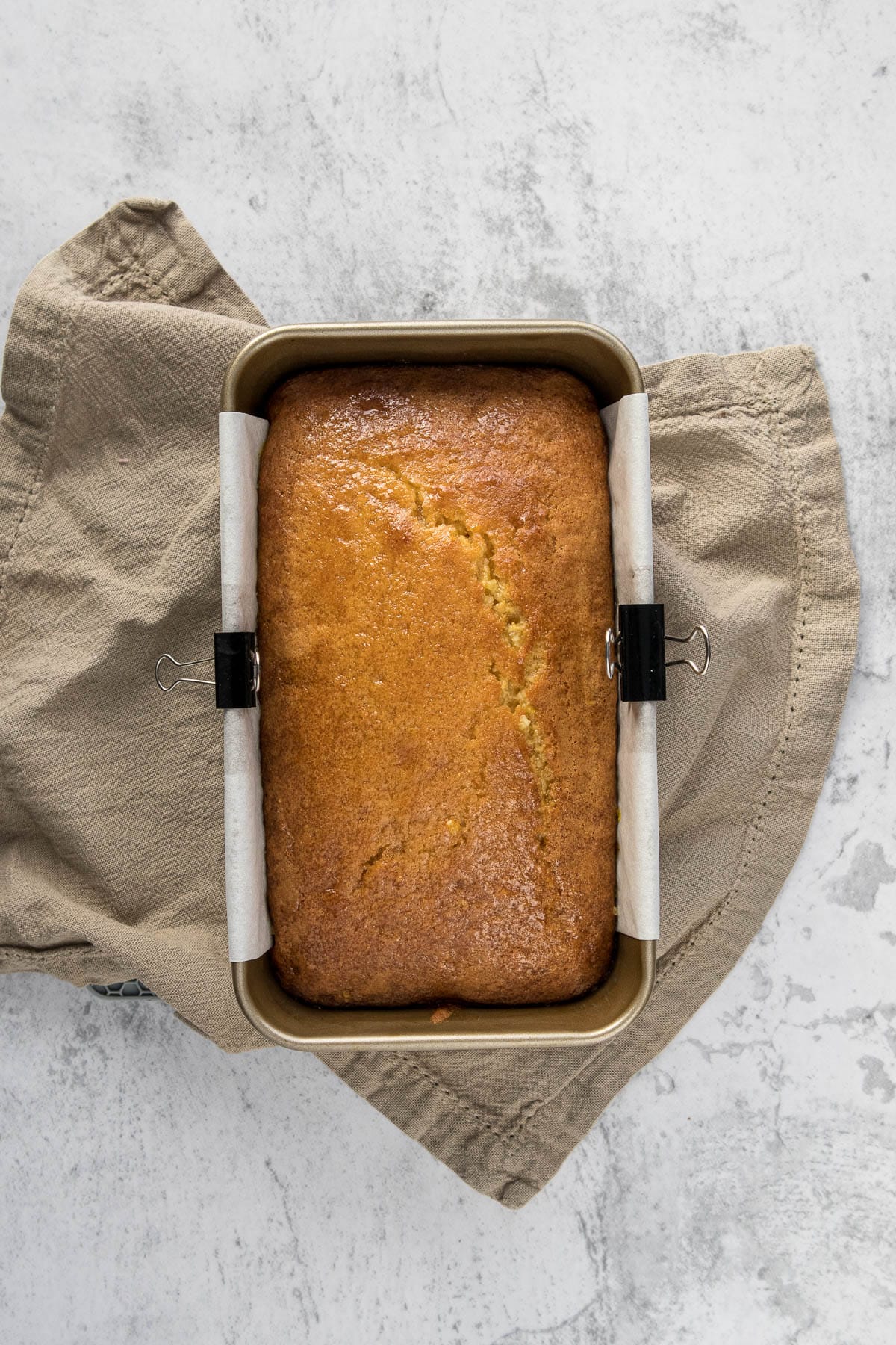 Baked orange loaf cake in loaf tin.