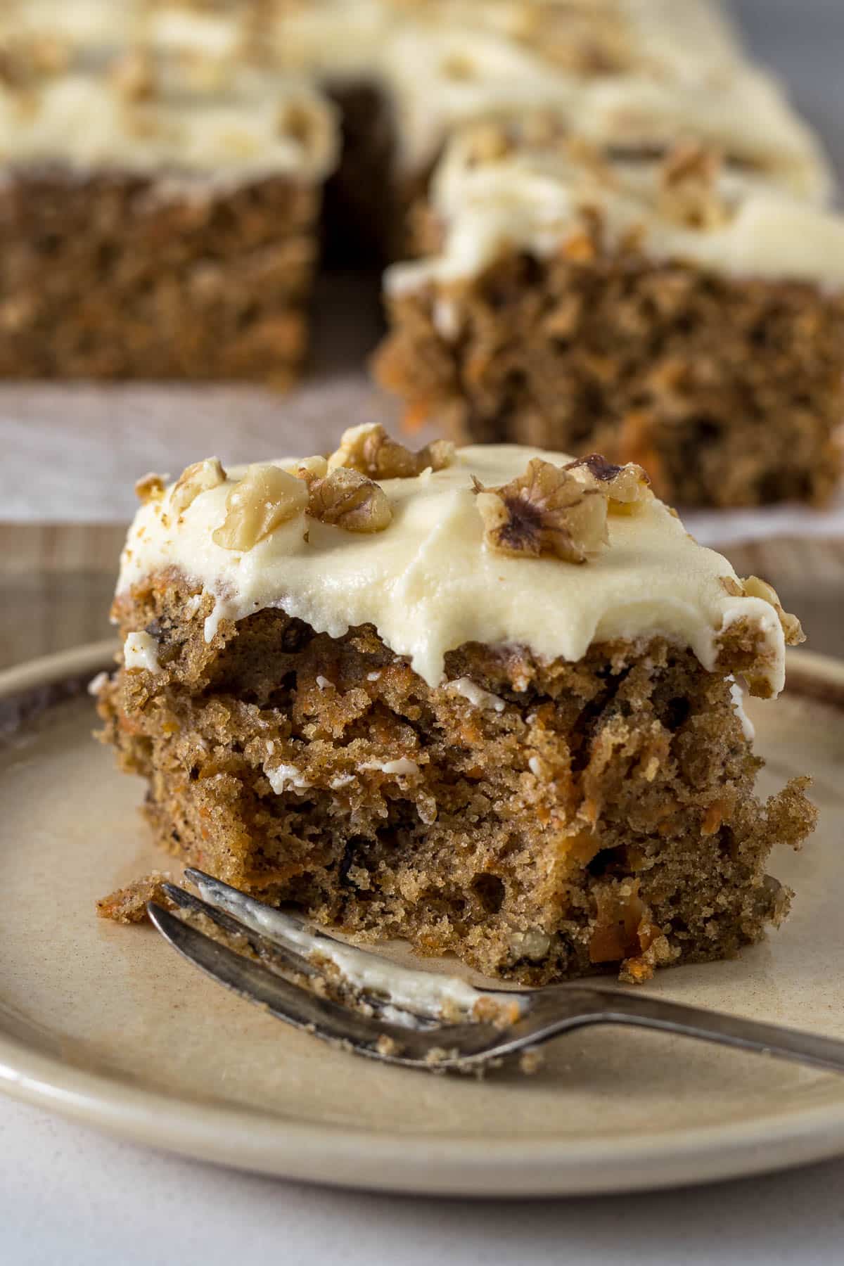 Sliced carrot cake tray bake on a plate.