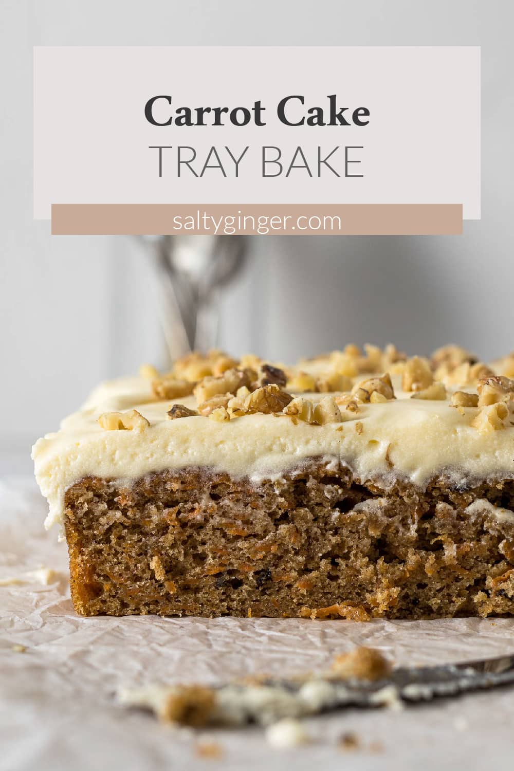 Sliced carrot cake tray bake with cream cheese frosting.