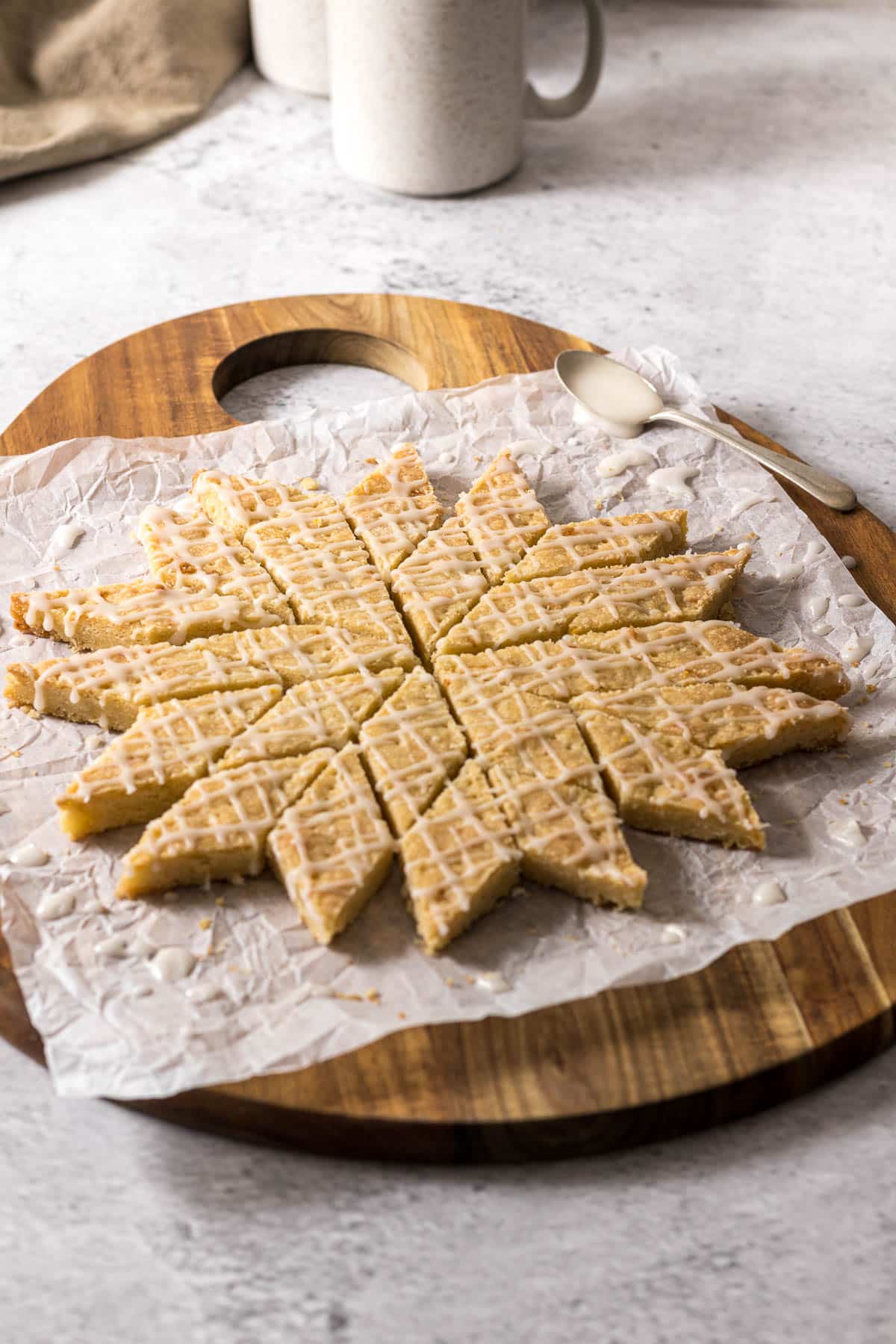 Sliced and glazed lemon shortbread on a board.