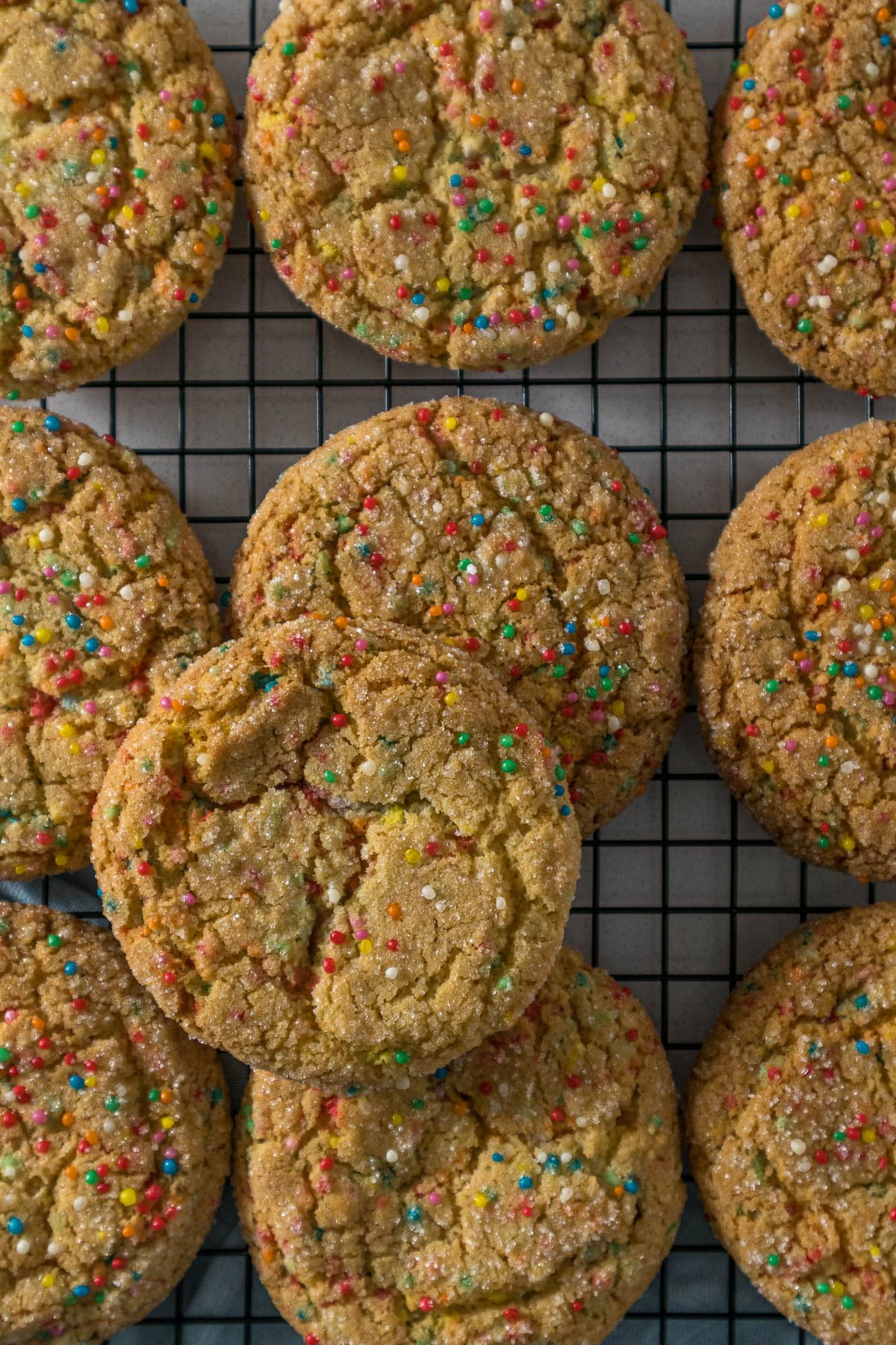 Sugar cookies with sprinkles on a cooling rack.