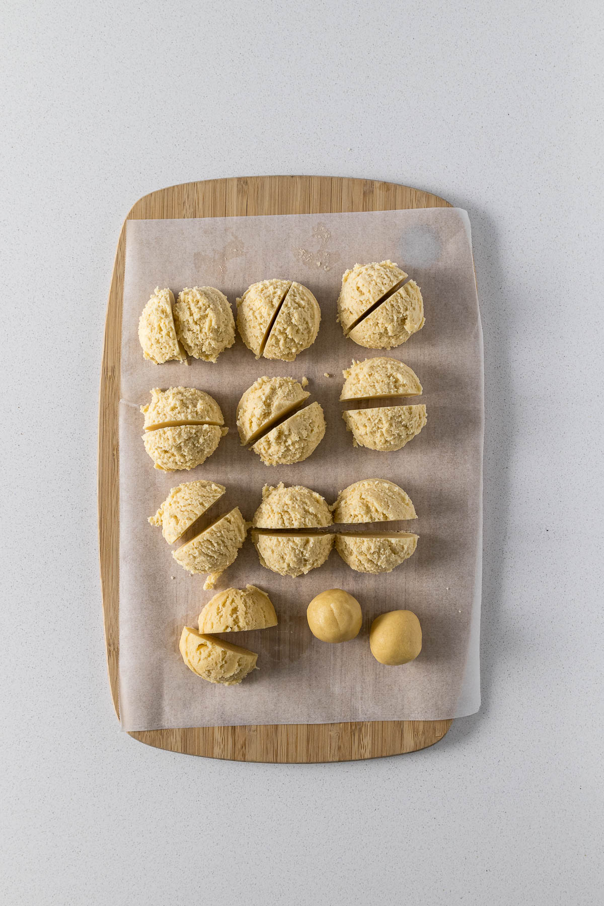 Portioned and rolled cookie dough on baking paper.