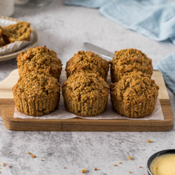 Bran muffins on a wooden platter.