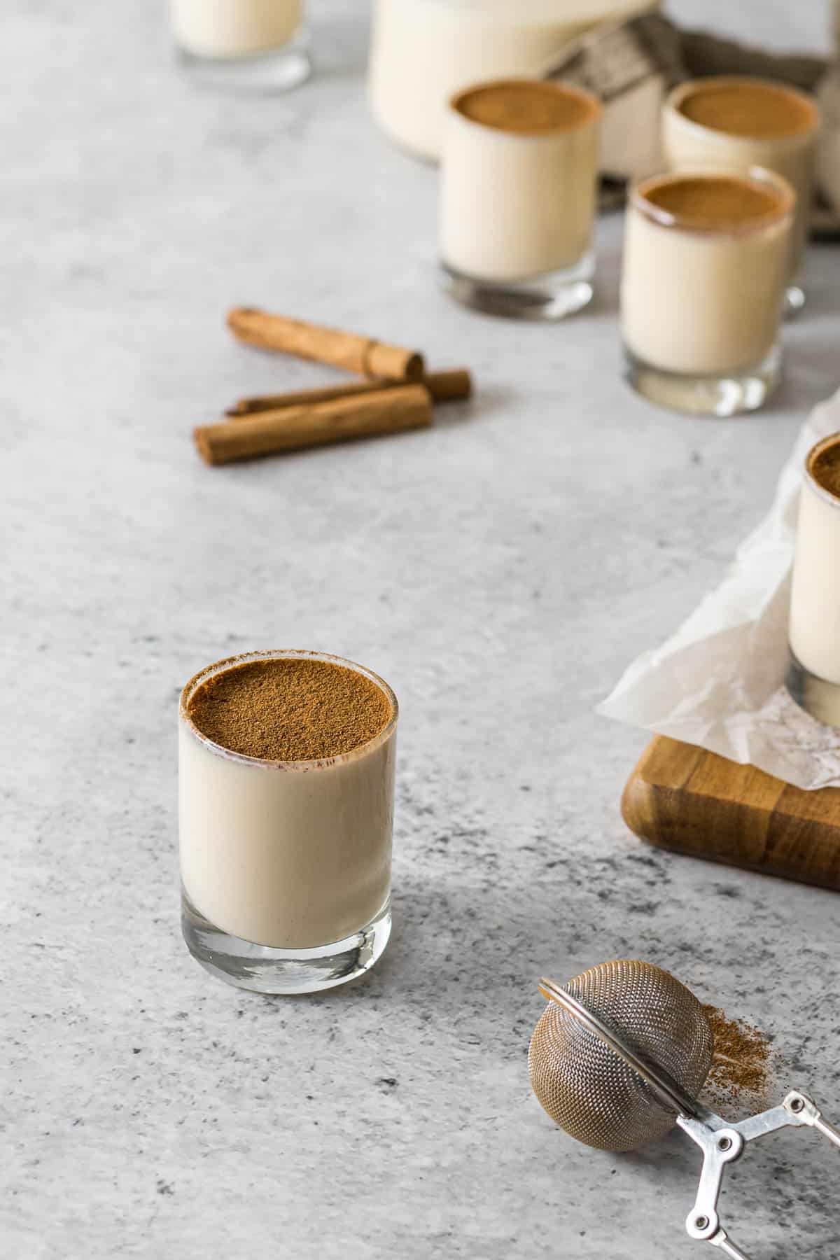Melktertjies (milk tart shooter) topped with ground cinnamon.