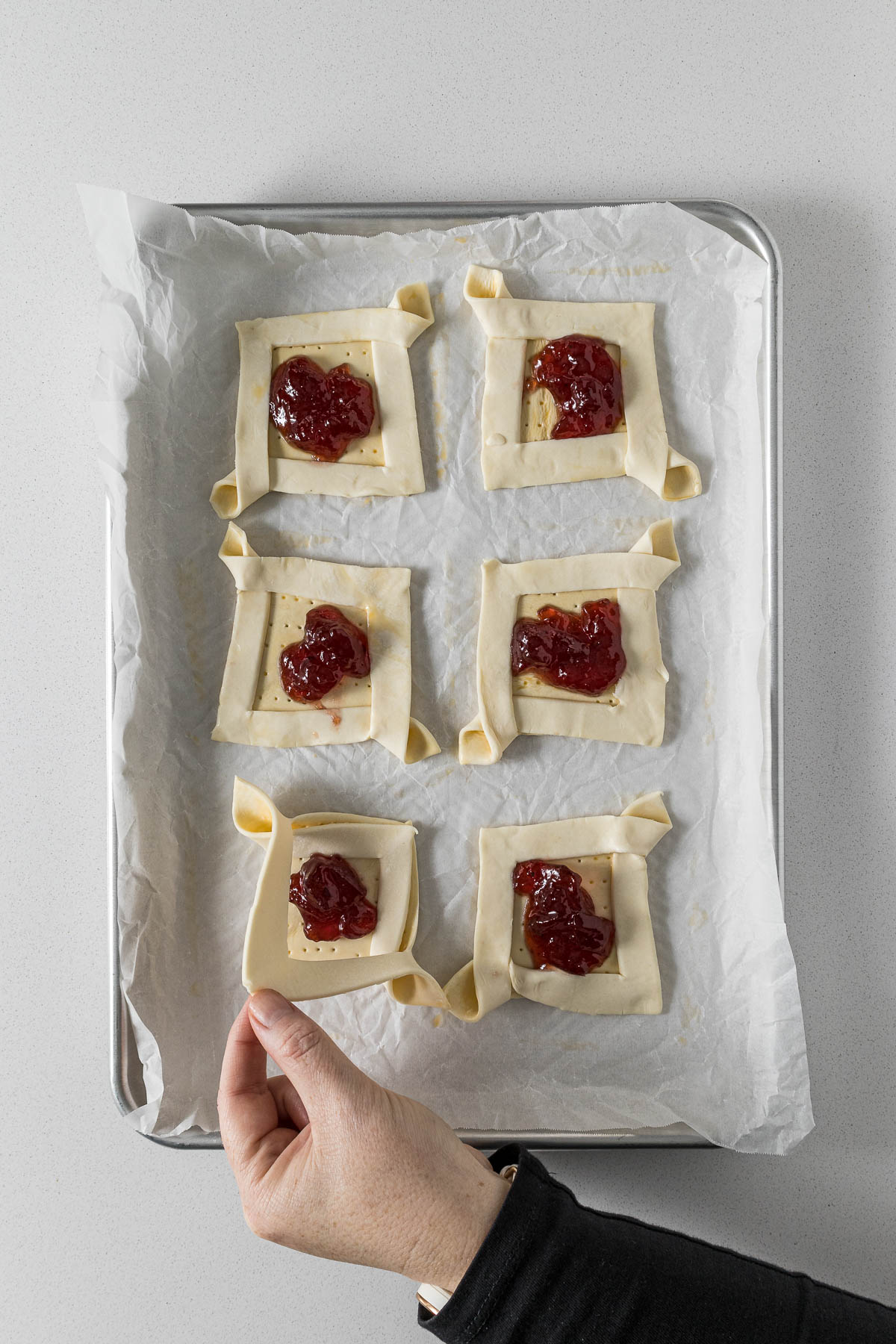 Step 7 - jam placed on the puff pastry and corners folded across each other.