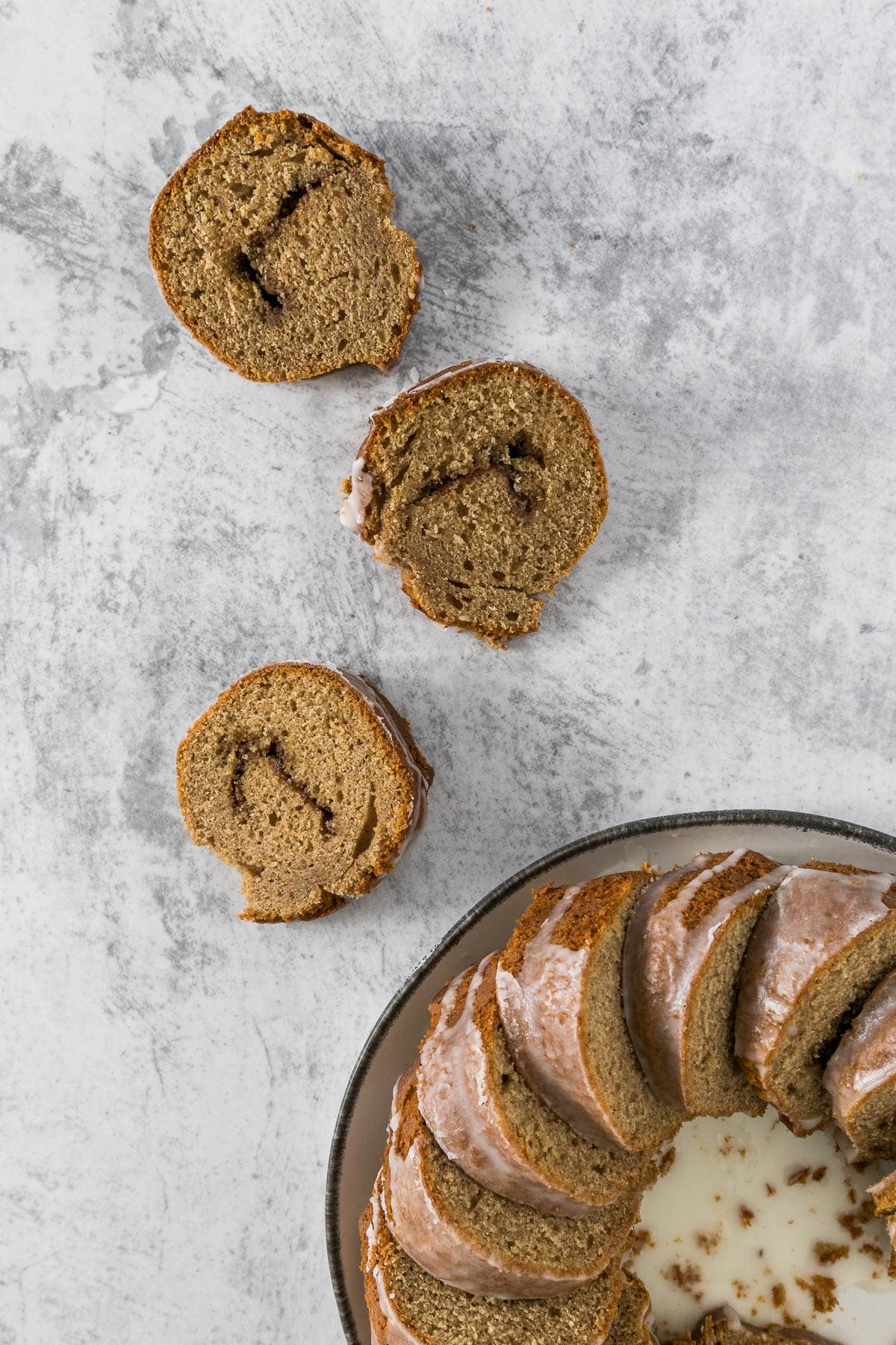 Sliced cinnamon bundt cake on a marble top.