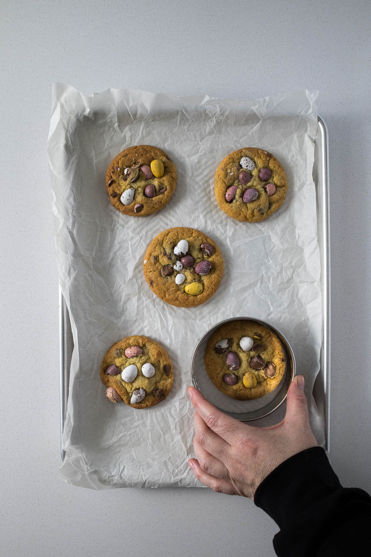 Step 12 - cookies being scooted into a perfect round using a large cookie cutter.