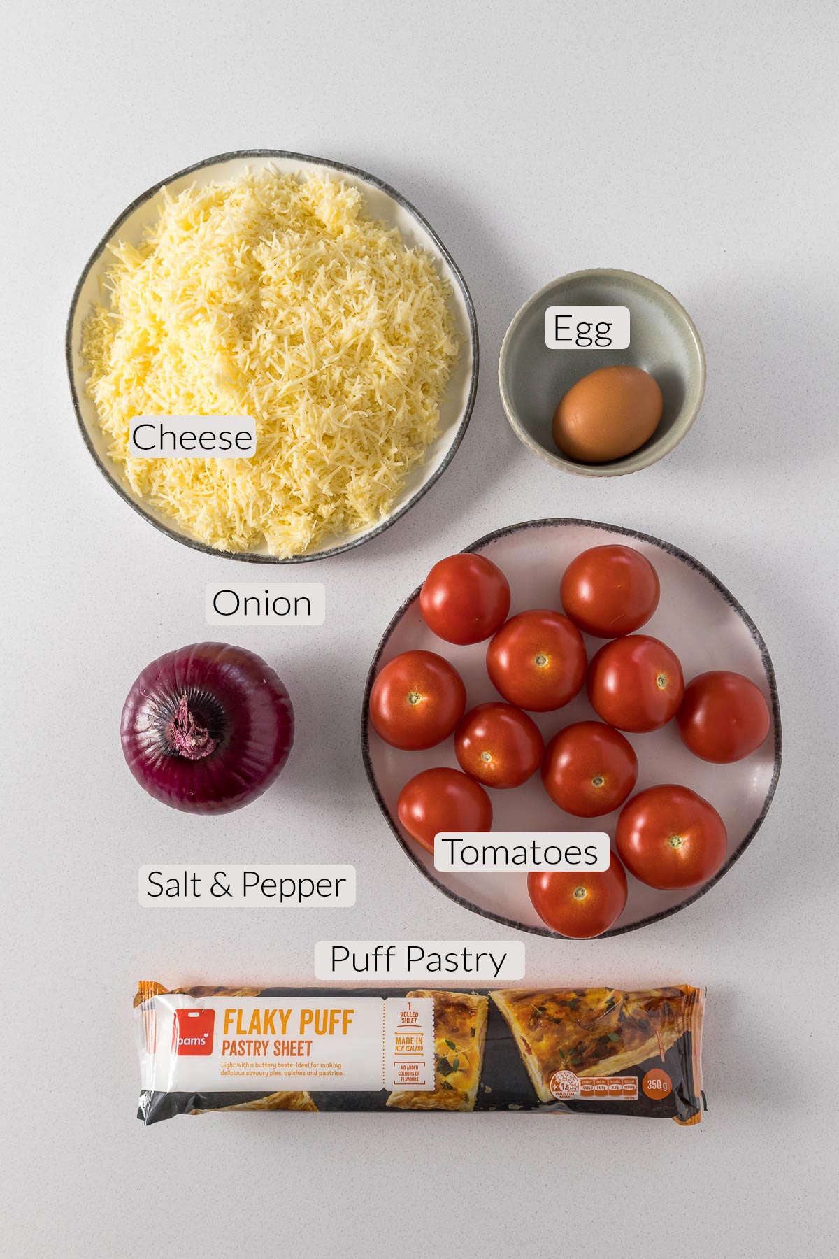 Tomato puff pastry ingredients - cheese, eggs, onion, tomato, puff pastry.