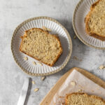 Slice of banana bread with almonds on a plate.