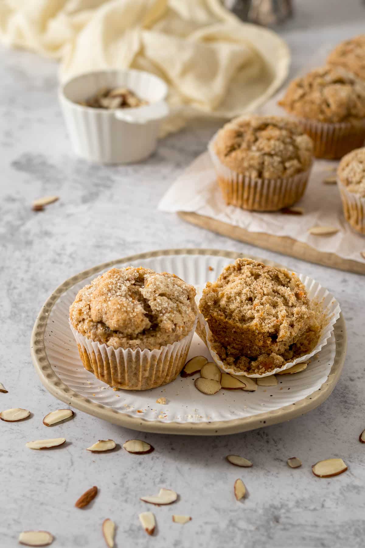 Banana carrot muffin cut in half on a plate.