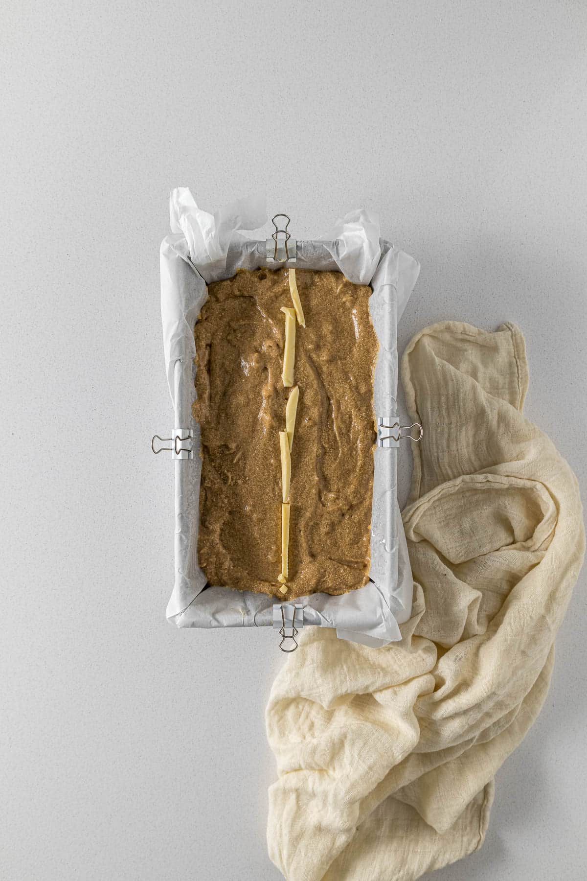 Step 7 - cake batter in loaf tin with stripe of butter.