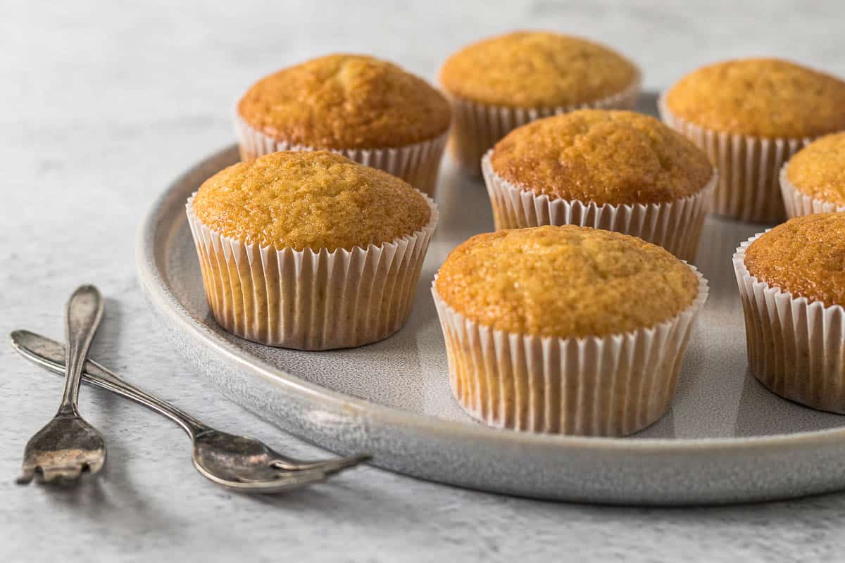 Unfrosted vanilla cupcakes on a plate.