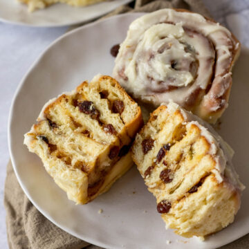 A Chelsea bun sliced in half on a plate.