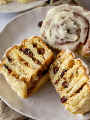 A Chelsea bun sliced in half on a plate.