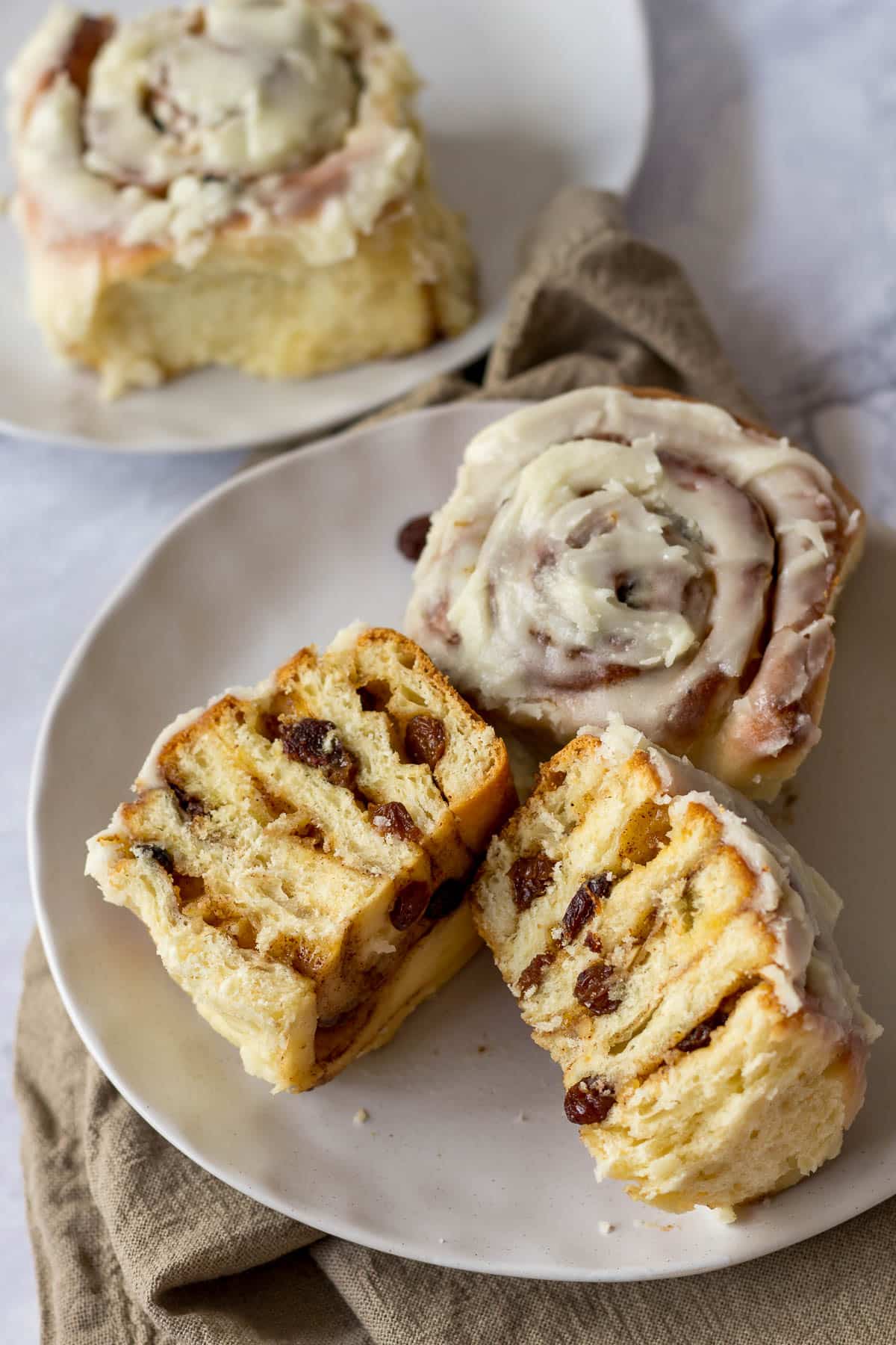 A Chelsea bun sliced in half on a plate.