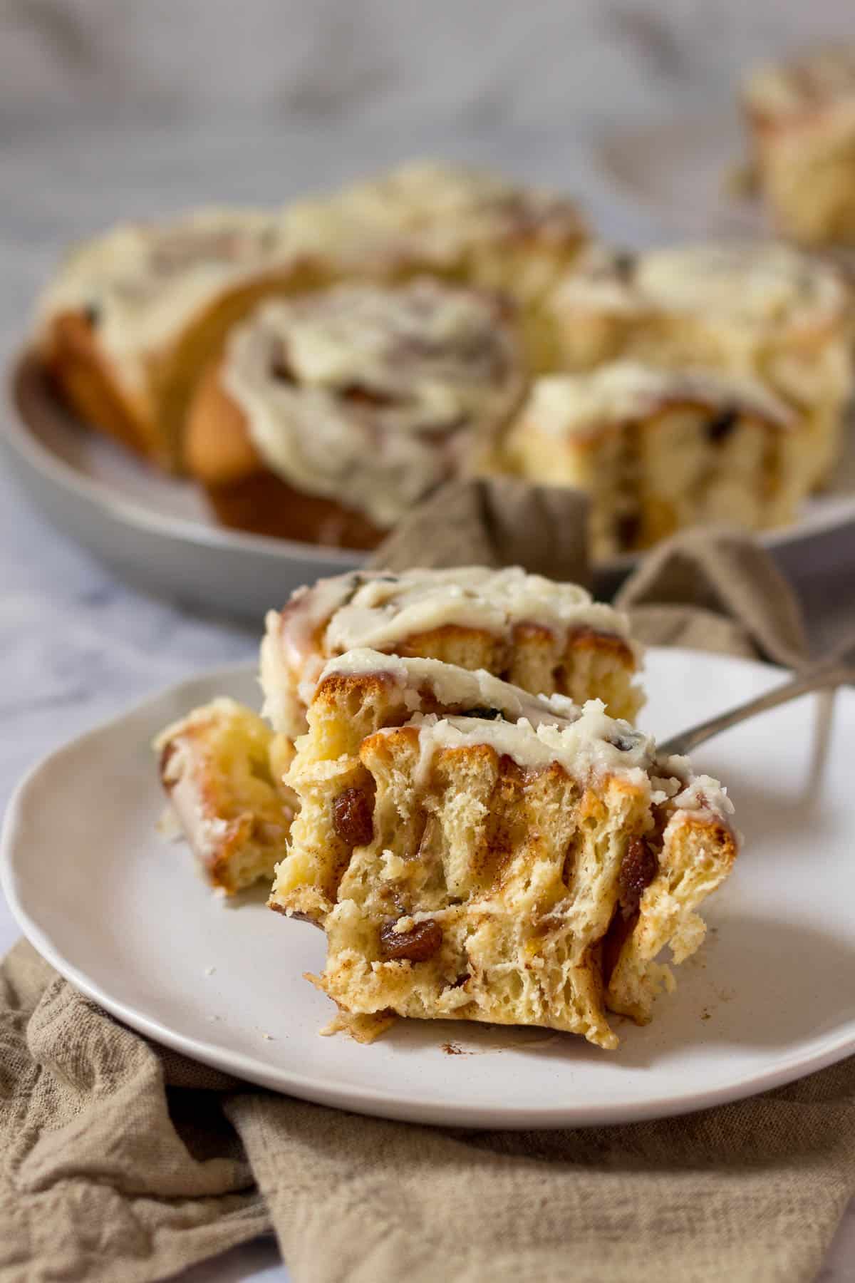 Chelsea bun on a plate cute in half to show the middle with filling.