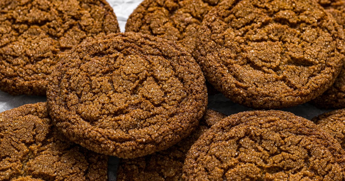 Ginger biscuits stacked on each other on a wire rack.