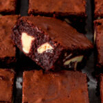 Close up of sliced red velvet brownie showing white chocolate chunks.