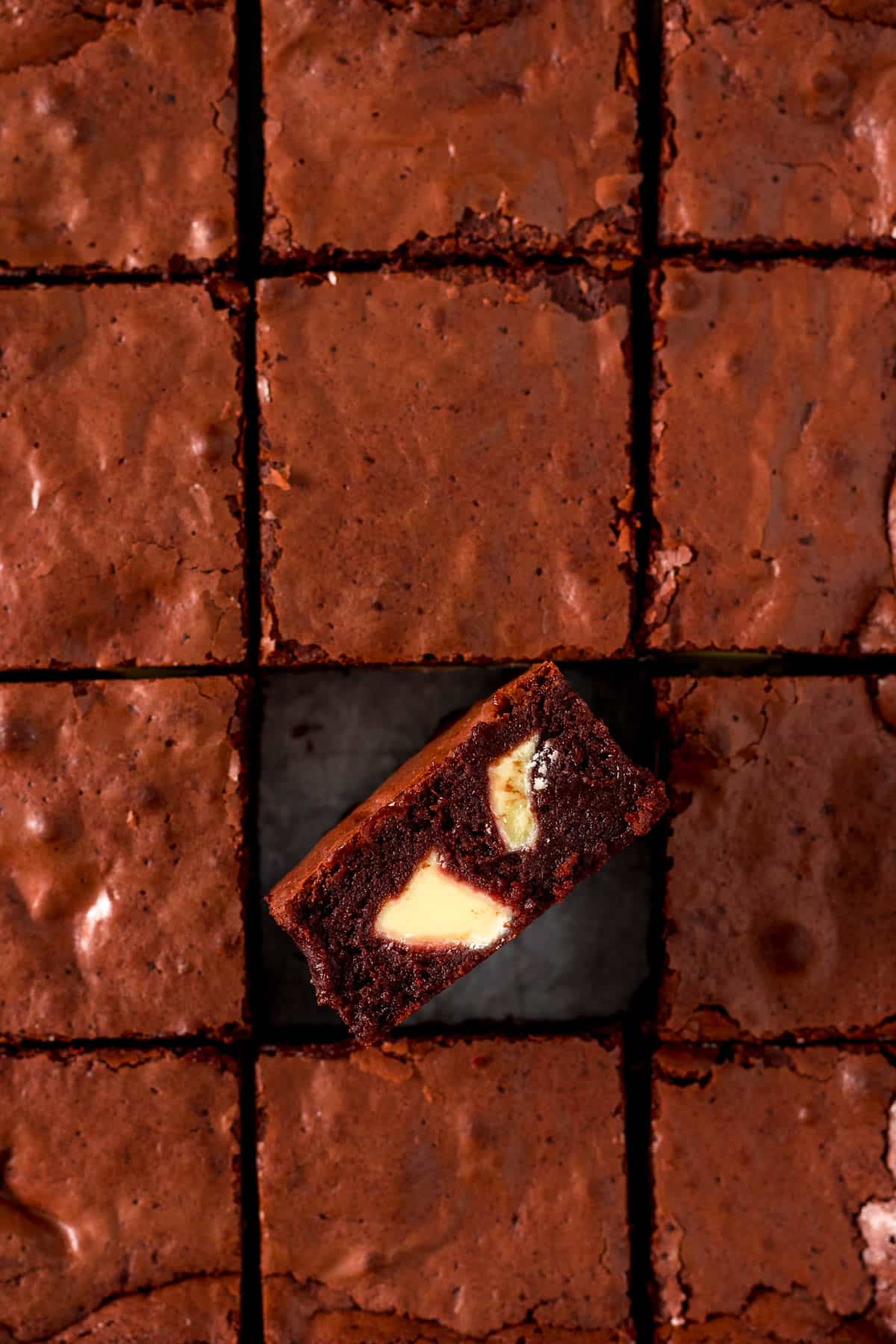 Sliced red velvet brownie with one turned on it's side showing white chocolate chunks.