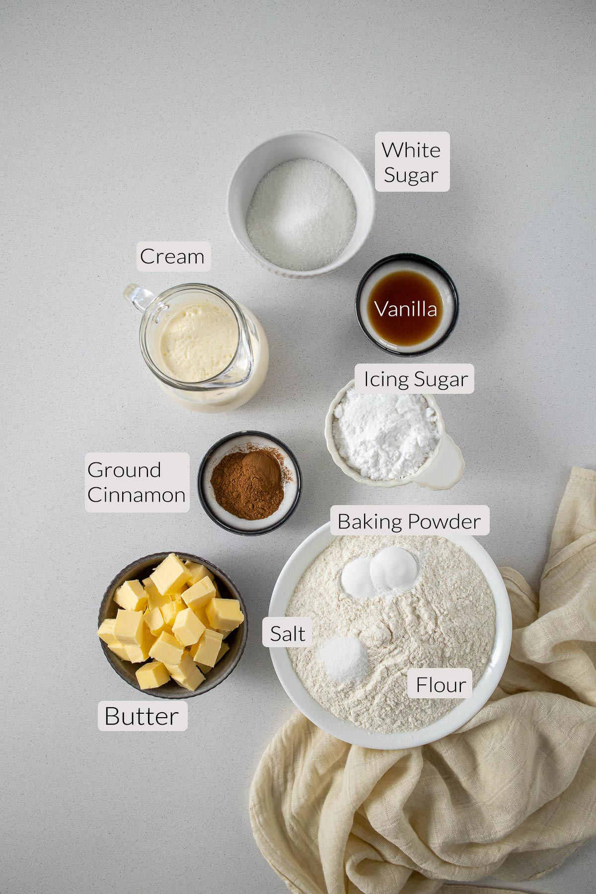 Cinnamon scones ingredients - sugar, cream, vanilla, icing sugar, flour, salt, baking powder, butter and ground cinnamon.