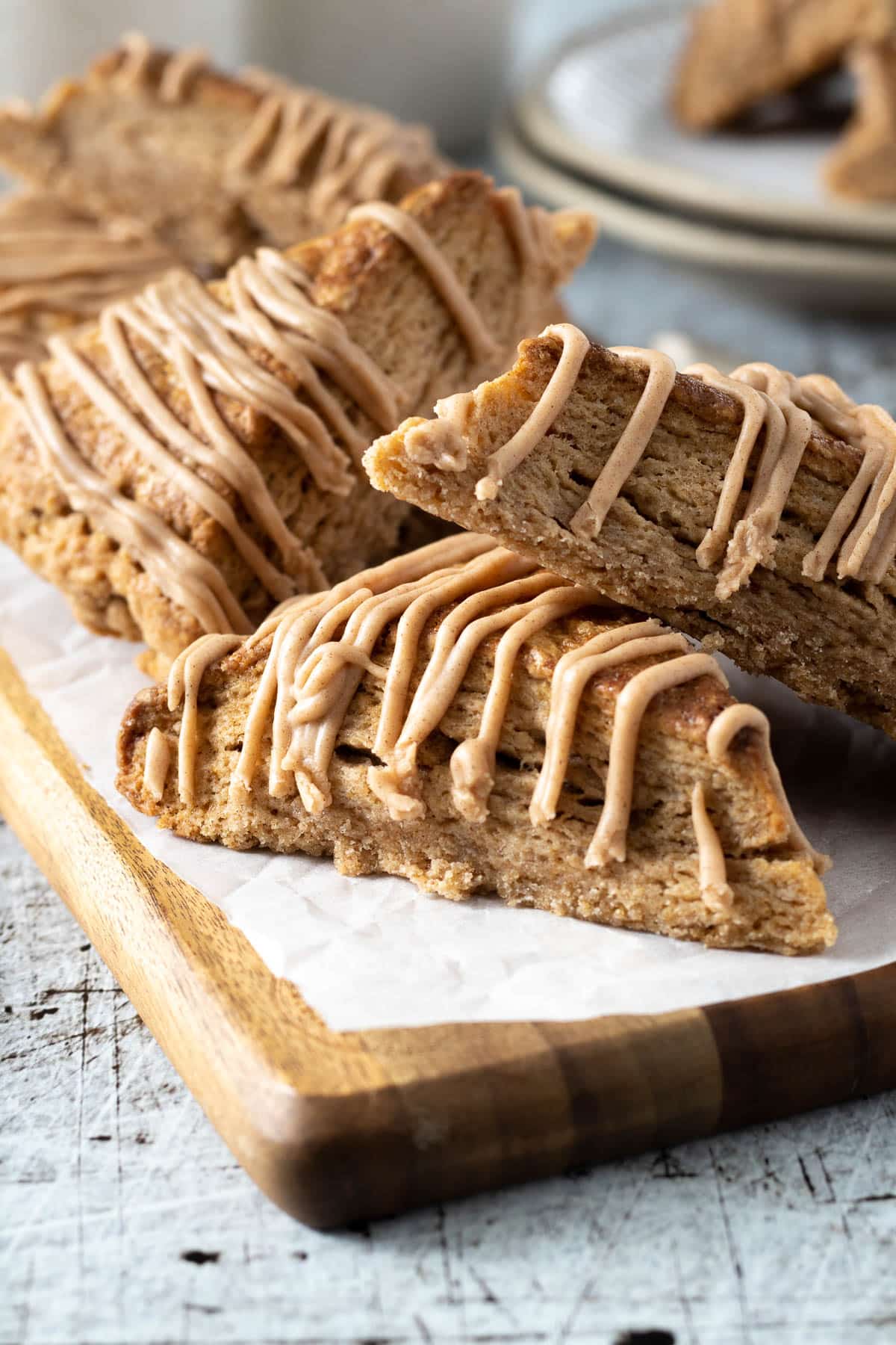 Cinnamon scones with a cinnamon glaze on a board.