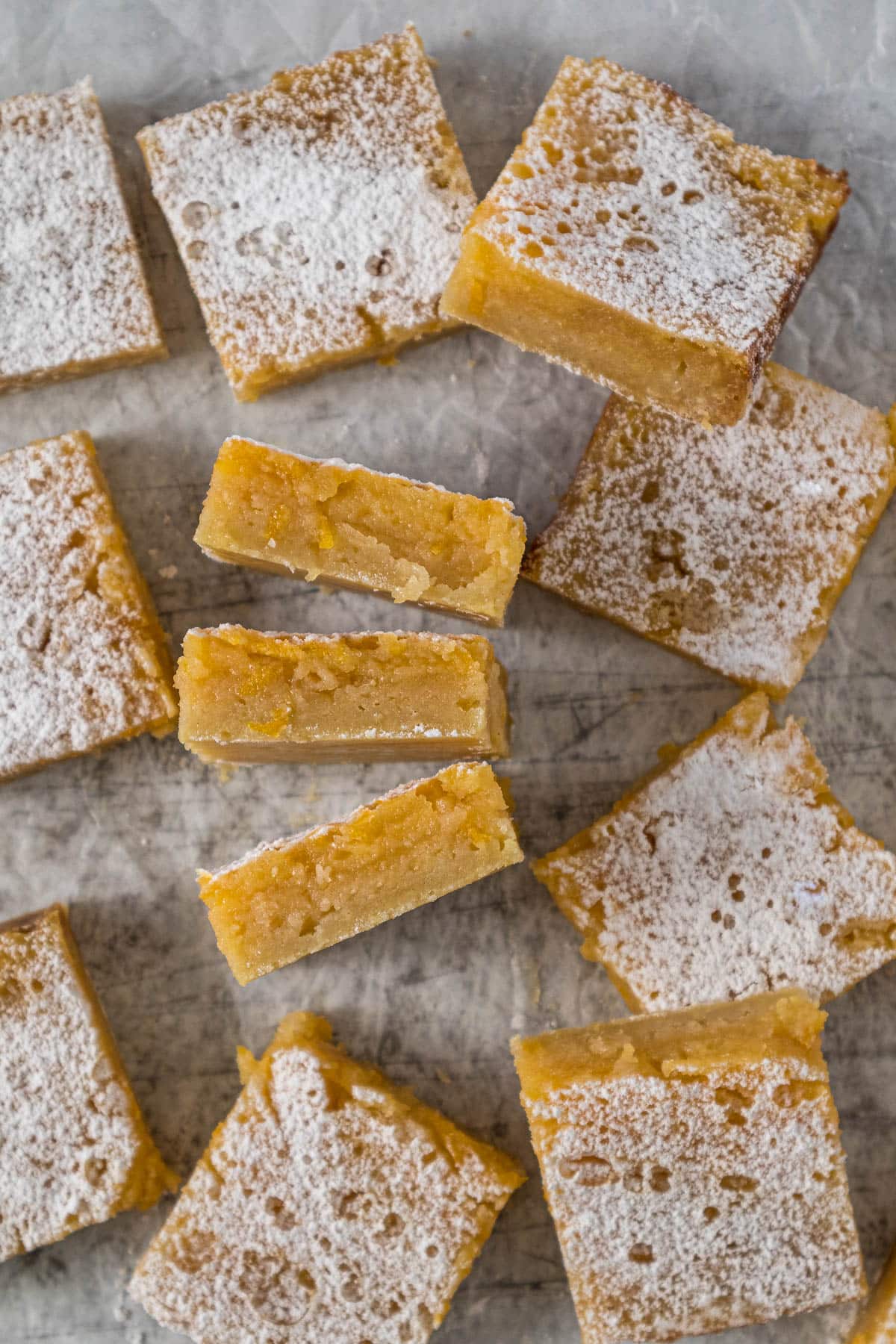 Lemon slices on parchment paper, with some on their sides to show the luscious lemon filling.