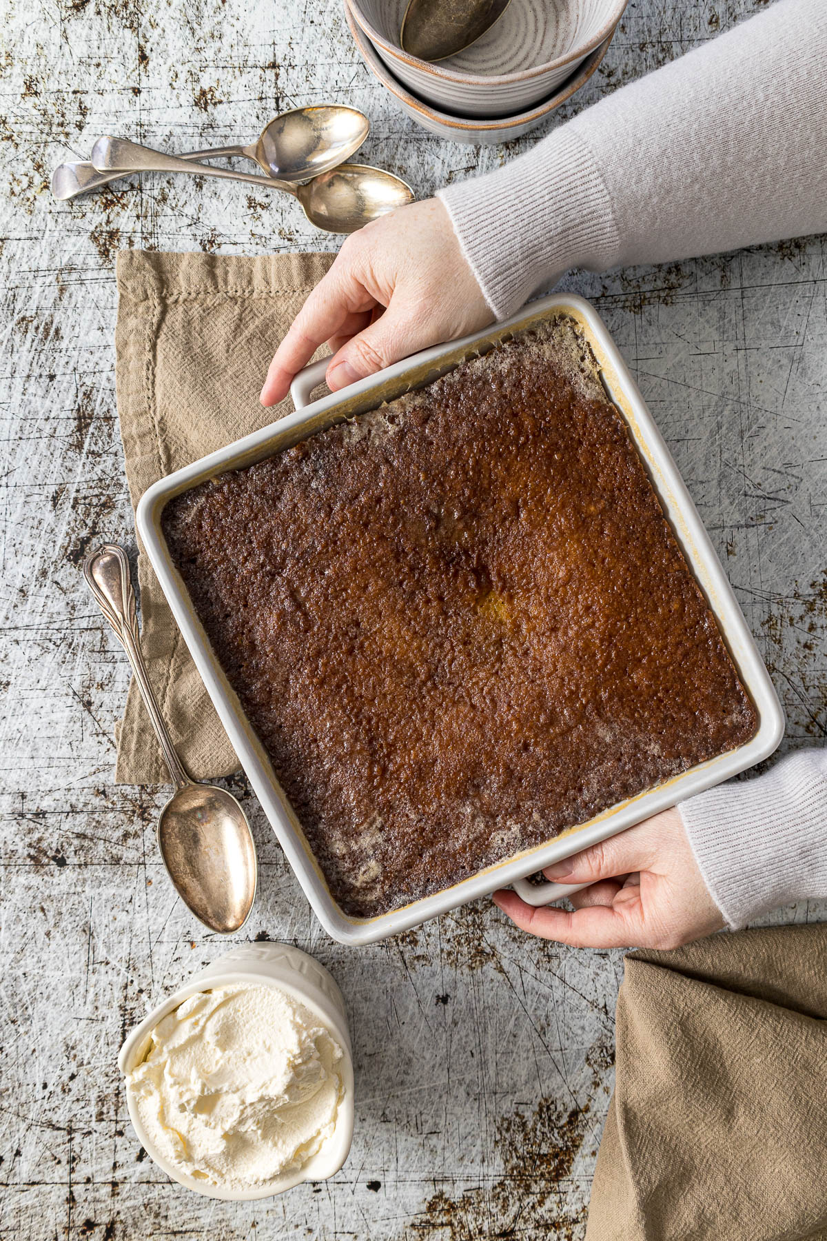 Malva pudding drenched in the sauce on table. 