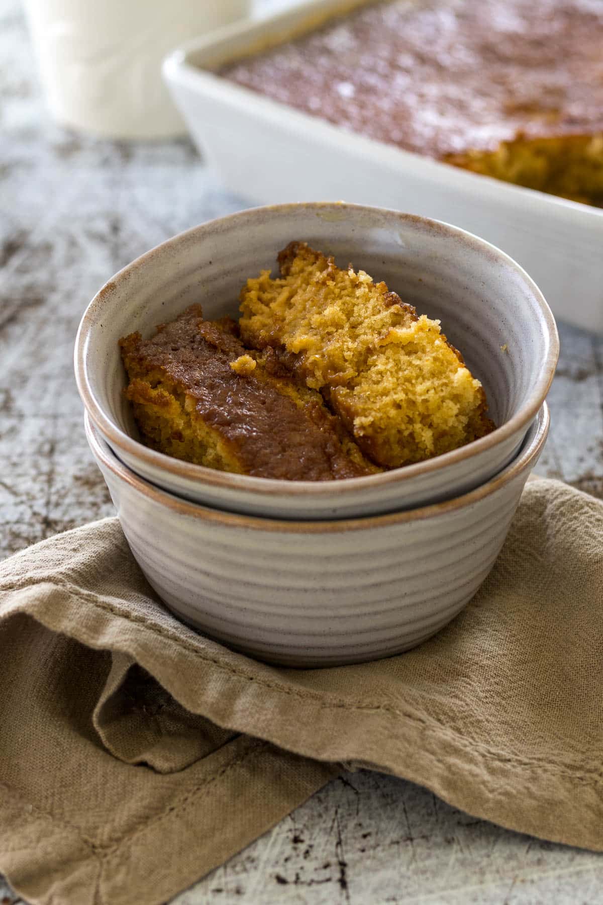 Bowl of Malva pudding on a linen napkin.