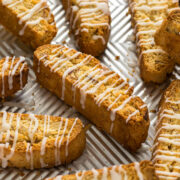 Lemon biscotti with a lemon glaze on a baking tray.